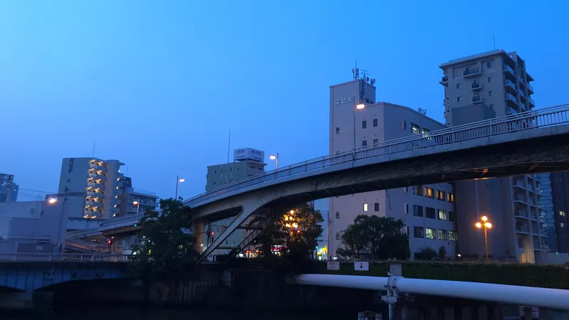 Picture of a bridge in Osaka during sunset with a saturated blue sky